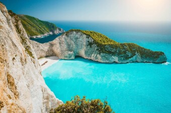 Navagio beach or Shipwreck bay panoramic. Turquoise sea water and white beach between huge cliffs. Famous landmark location on Zakynthos island, Greece