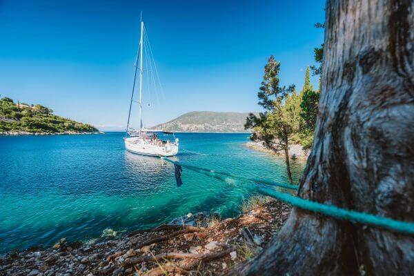 Sail boat on rope in emerald water